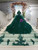 Back view of a dark green wedding gown showcasing the lace-up corset back, the full tulle skirt, and the flowing veil.