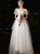 White tulle A-line wedding dress with a square neckline, short puff sleeves, and intricate floral appliqués, a vintage-inspired choice for a garden ceremony