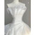 Close-up of the delicate pleats on the strapless bodice of a white organza wedding gown