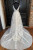 Stunning backless design of a white tulle wedding dress showing the open back and strap details.