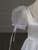 Voluminous puff sleeves with satin bow detail on a white wedding gown.