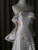 Close-up of the romantic off-shoulder ruffle detail and the luxurious satin fabric on an ivory tiered wedding dress.