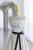 Close up of striking black ribbon belt cinching the waist of an ivory satin wedding dress