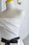 Close up of delicate pleats and draping on the bodice of an ivory wedding gown