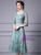 Close up of delicate floral embroidery on a green tulle mother of the bride gown