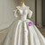 Close-up of beading and sparkle details on a white satin bridal gown