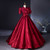 Front view of a burgundy jacquard prom dress with a structured bodice and full skirt