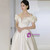 Bride in an off-the-shoulder satin ball gown at a romantic garden wedding venue.