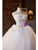Close‑up of intricate beading and sequin details on the bodice of a white tulle strapless wedding dress