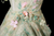 Close-up of pastel floral appliques on strapless green tulle prom dress
