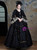 Close-up of the intricate baroque lace pattern and rich texture on a black long sleeve Rococo-inspired vintage dress.