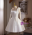 Close-up of the detachable sheer sleeve and delicate bow embellishment on a white satin homecoming dress, highlighting the romantic, ethereal detail.

