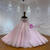 The layered rosy champagne tulle skirt creates a full, flowing volume, its surface kissed by soft sequin sparkles that catch the light like morning dew.