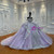 The layered lavender tulle skirt creates a full, flowing volume, its surface adorned with floral appliqués that seem to float across the fabric.