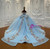 The show-stopping back of a blue ball gown featuring a large, structured tulle bow at the waist and a lace-up corset, ready for a grand entrance.