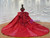 Close-up of the stunning sequin and lace applique embellishments on the off-shoulder bodice of a red tulle wedding gown.