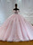 Pink tulle ball gown wedding dress with an off-the-shoulder neckline, delicate lace appliques, and a full flowing skirt.