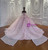 Detailed view of the layered pink tulle skirt and the elegant bow embellishment at the back of this romantic wedding gown.