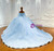 Lace-up corset back of blue tulle ball gown with puff sleeves and floral embellishments