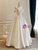 Side view of an A-line satin wedding dress with off-the-shoulder sleeves, highlighting the graceful drape and movement