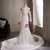 Sweep train and back button closure detail on white mermaid lace wedding dress