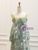 Close-up detail of the green sequins prom dress showcasing the sheer tulle bow straps and delicate green beaded floral embellishments on the bodice.