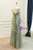 Back view of the green sequins prom dress showing the fitted bodice, elegant back design, and the floor-length flowing sequin skirt.