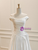 Detail showing the sweeping floor-length hemline and the silky satin skirt.