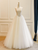 Detail view showcasing the sweep train and the delicate blend of beige and white tones.