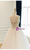 Side/back angle showing the corset lace-up back and cascading tulle layers.