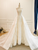  Front view of the beige white bridal gown showcasing the full A-line silhouette with the tulle overskirt.