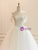 Close-up of the intricate floral lace appliques and structured strapless neckline.