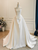 Front view of the heavy ivory satin gown with deep pleated folds.