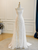 Front view of the glittering white sheath lace gown.