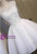 Front view of a sleeveless white homecoming dress with a scoop neckline