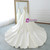 Back view of an ivory satin ball gown showing the dramatic long train and button details.