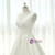 Close-up of the structured pleats on the bodice and waistband of an ivory satin V-neck wedding dress