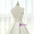 Close-up of the structured pleats on the bodice and waistband of an ivory satin V-neck wedding dress