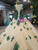 Close up of green lace appliqués on champagne tulle wedding dress bodice
