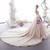 Bridal back view showcasing the open lace-up back and the sweeping cathedral train of a champagne tulle wedding gown with floral appliqués.