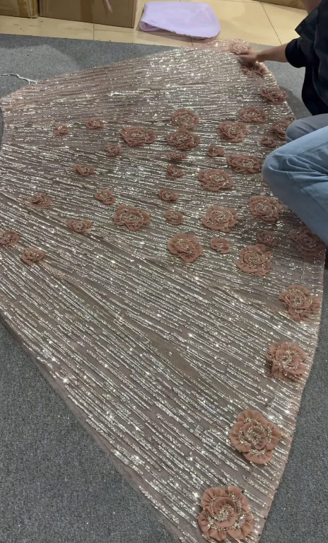 Process of cutting circular pieces from champagne pink chiffon to create the hundreds of 3D flowers for the gown