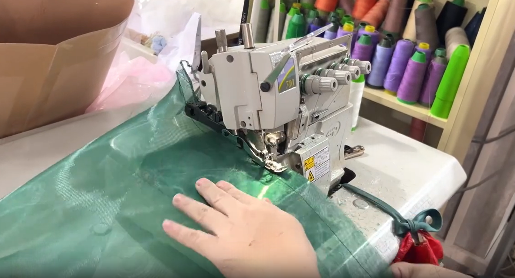 Green tulle being stitched on sewing machine
