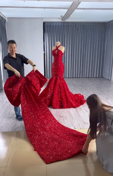 Final Hand Adjustment on Custom Wedding Dress Hand adjusting waist seam of red sequin custom wedding dress
