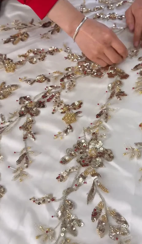 Hand setting sequins onto floral embroidery Hand setting sequins onto floral embroidery
