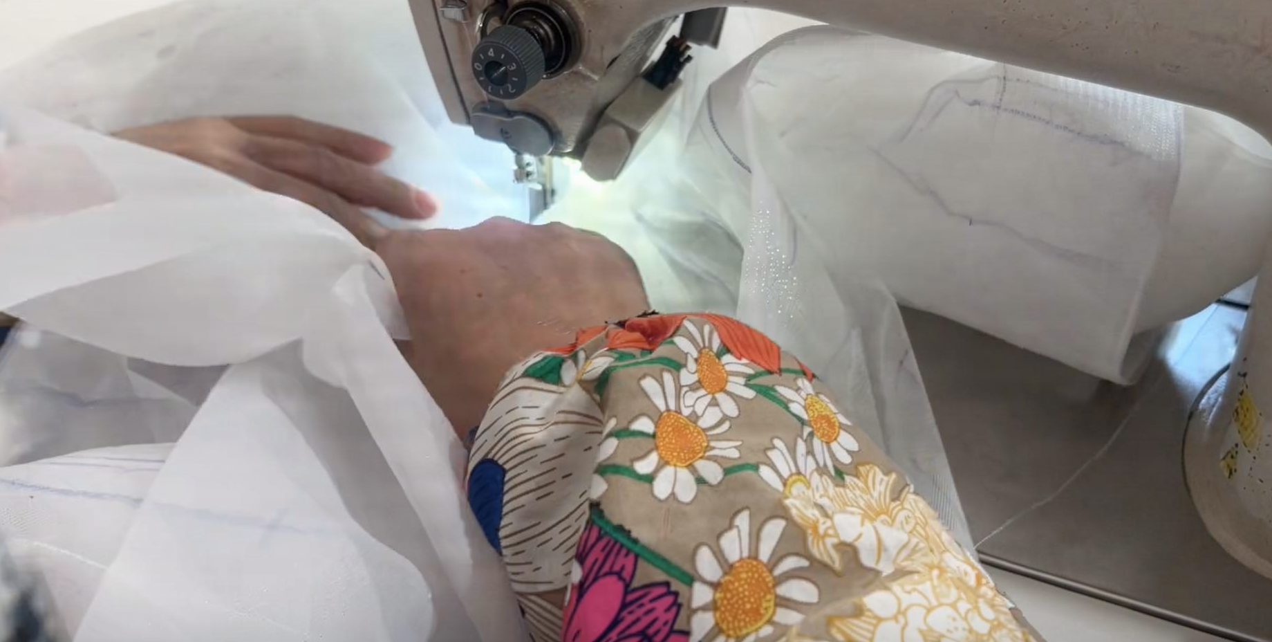 Hand sewing layered tulle petals during the three dimensional rose gown construction process