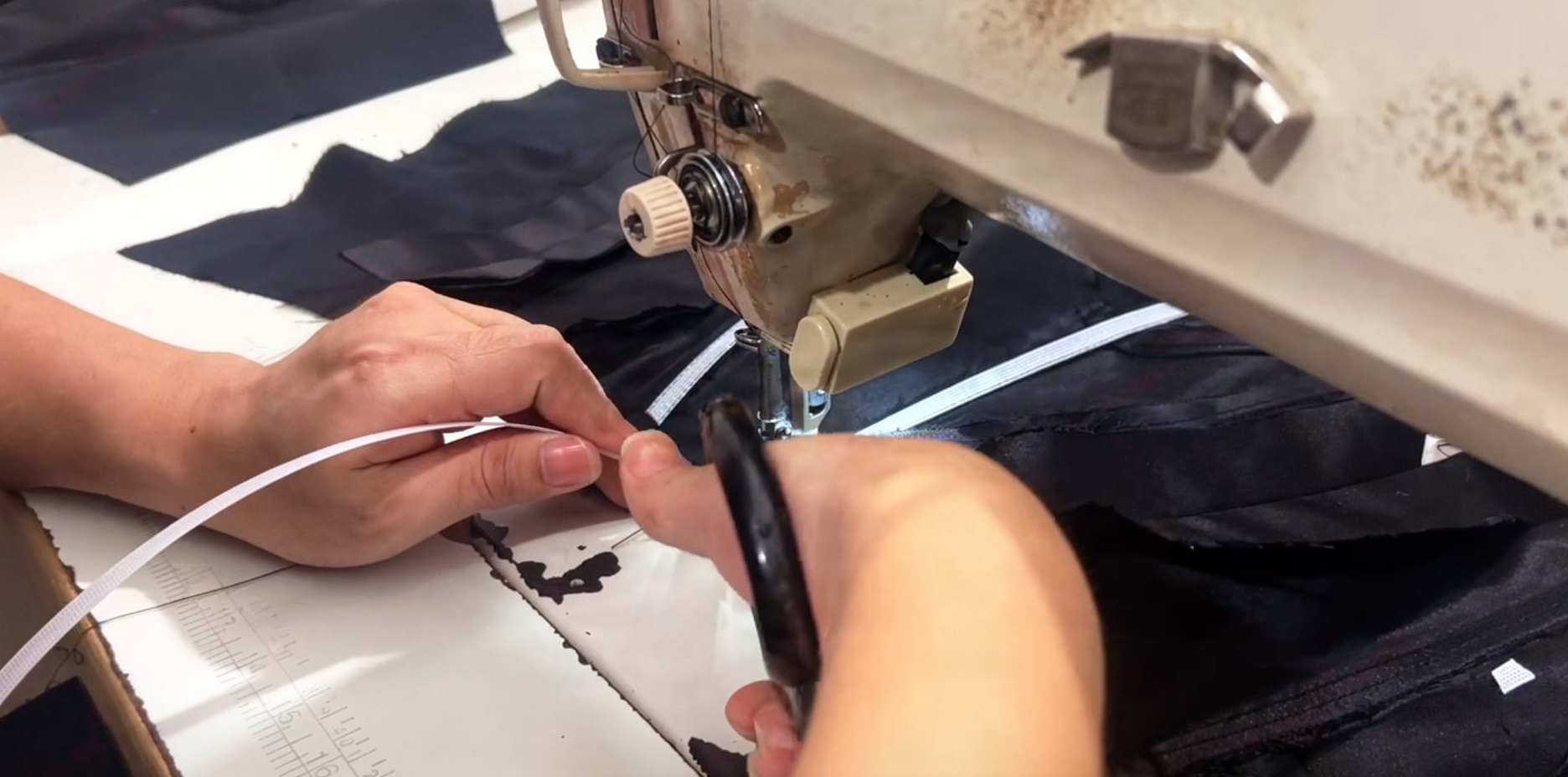 Flexible woven polyester boning being installed inside black velvet gown bodice