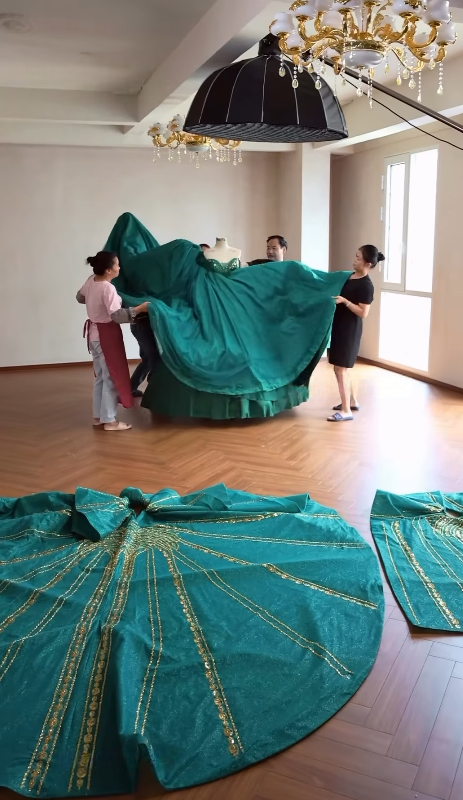 Workers preparing large ball gown skirt fabric