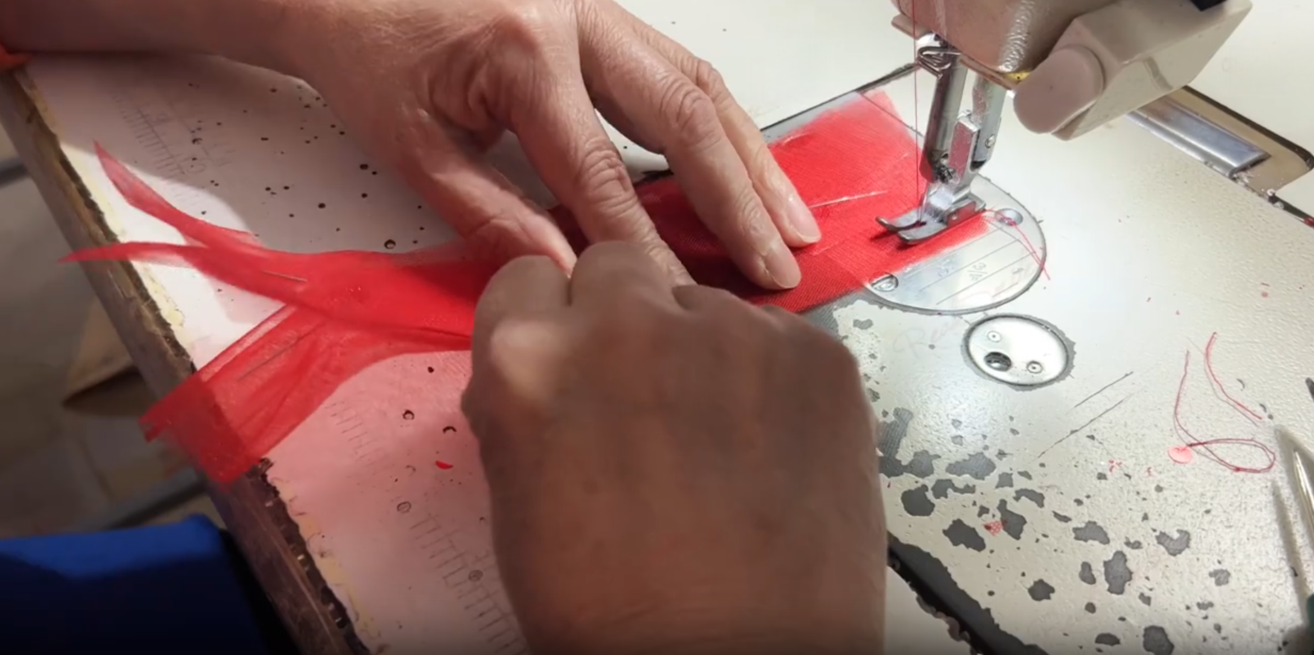 Machine stitching tulle panels for red mermaid wedding dress