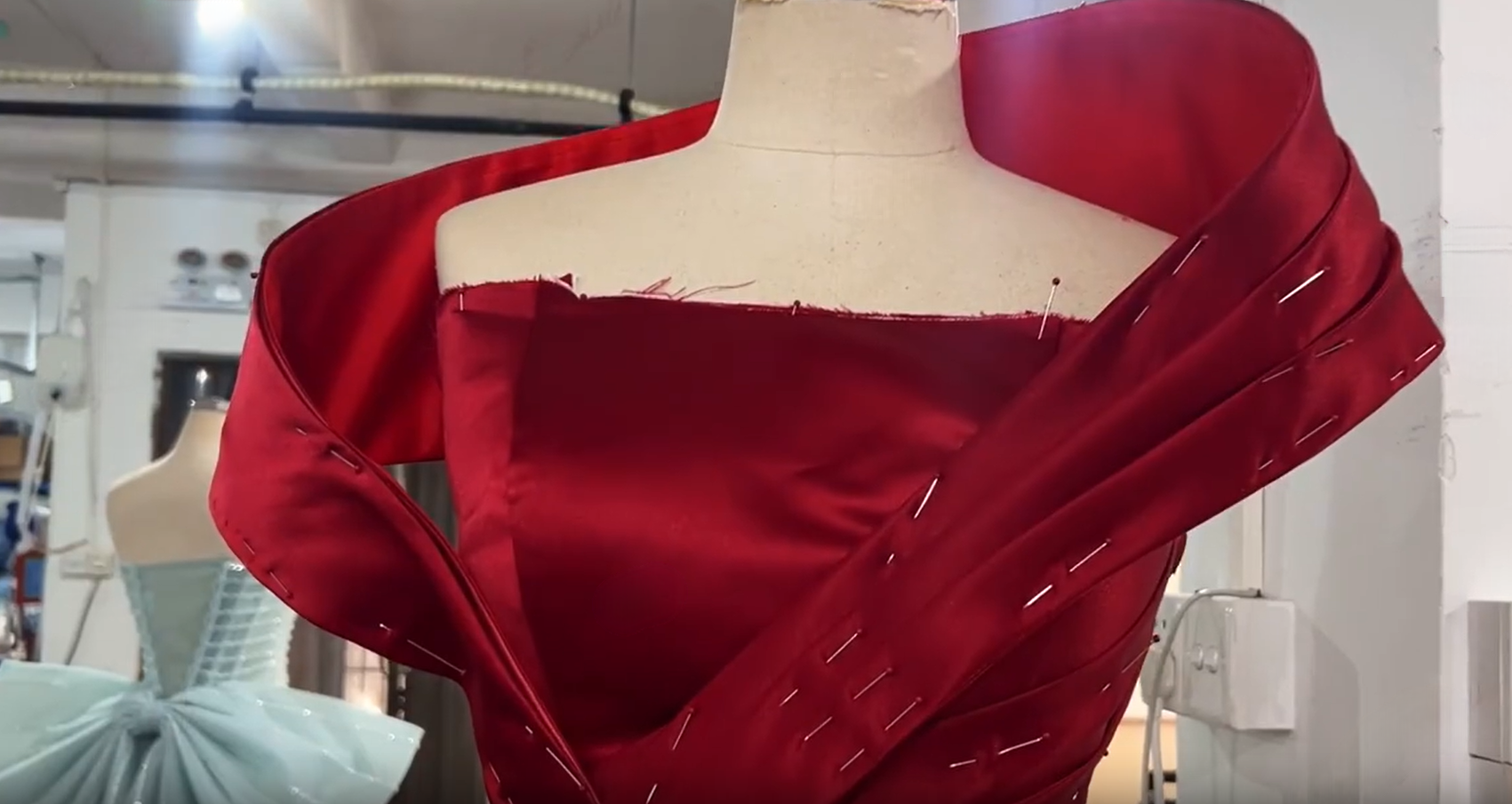 Sculpted off shoulder satin collar on a red formal gown dress form