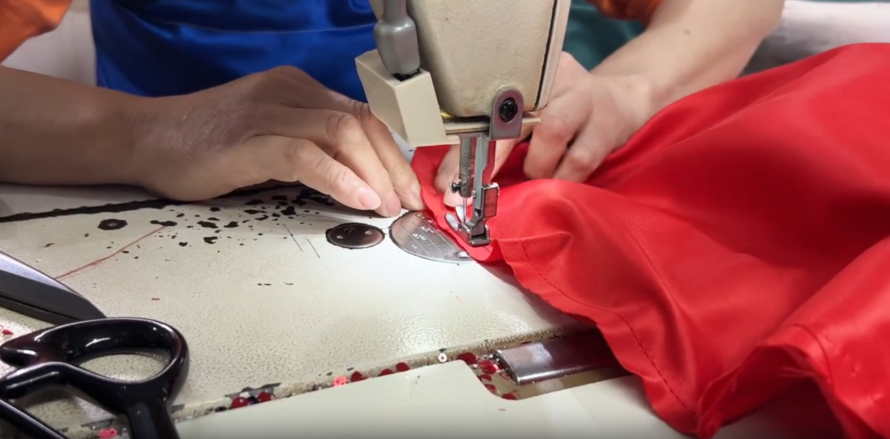 Red satin lining being sewn into custom wedding dress